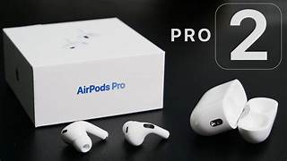 A pair of Apple AirPods Pro (2nd Generation) with a white MagSafe charging case, featuring a sleek, compact design. The earbuds have short stems, silicone ear tips for a secure fit, and advanced noise-canceling technology. The charging case includes a built-in speaker and a lanyard loop for convenience