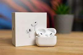 A pair of Apple AirPods Pro (2nd Generation) with a white MagSafe charging case, featuring a sleek, compact design. The earbuds have short stems, silicone ear tips for a secure fit, and advanced noise-canceling technology. The charging case includes a built-in speaker and a lanyard loop for convenience